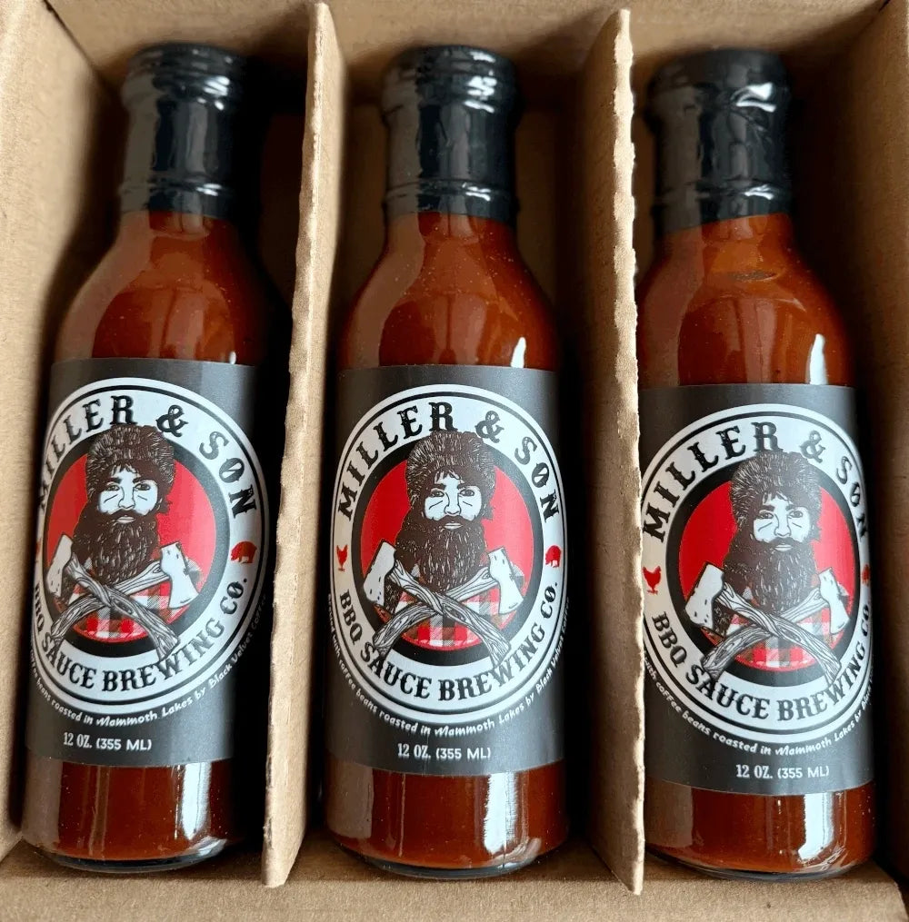 Three bottles of Miller & Son BBQ Sauce Brewing Co. hot sauce arranged in a cardboard tray.
